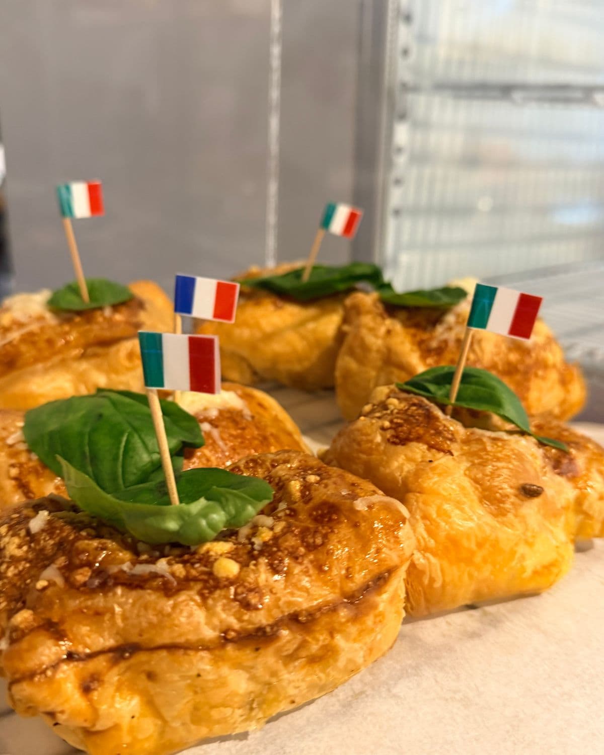 Merdeneaua Italiana: merdenele cu brânză gratinată, frunze de busuioc și stegulețe italiene.